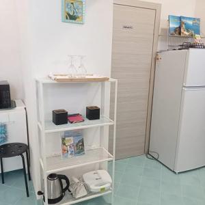 a kitchen with a white refrigerator and a table and a chair at Domus Julia in Furore