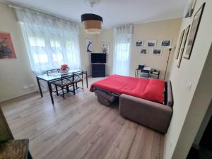 1 dormitorio con cama roja y mesa en Maison Martina 'Free Parking' en Aosta