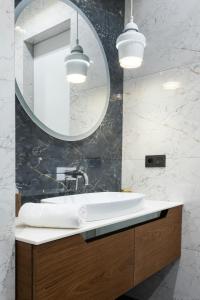 Hotel Aurora Mirage Delhi في نيودلهي: حمام مع حوض ومرآة