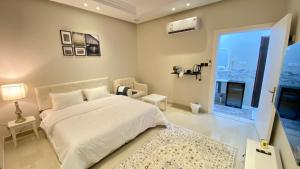a bedroom with a large white bed and a window at RIVIERA دخول ذاتي self check-in in Riyadh