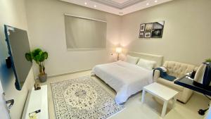a bedroom with a bed and a table and a lamp at RIVIERA دخول ذاتي self check-in in Riyadh