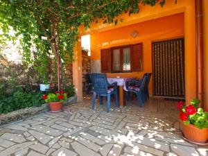 een oranje huis met een tafel en stoelen op een patio bij Ferienwohnung für 5 Personen ca 75 qm in Marčana, Istrien Südküste von Istrien in Marčana