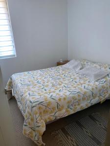 - une chambre avec un lit et une couette jaune et blanche dans l'établissement Departamento para 6 personas amoblado, à Los Andes