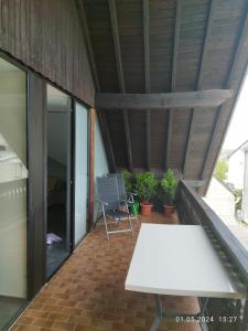 balcone con tavolo bianco e alcune piante di Ferienwohnung Jessica a Mastershausen