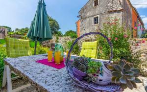 a table with a basket of plants and an umbrella at Ferienhaus für 5 Personen ca 70 qm in Rakalj, Istrien Bucht von Raša in Rakalj