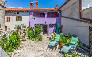 a group of chairs and a purple house at Ferienhaus für 5 Personen ca 70 qm in Rakalj, Istrien Bucht von Raša in Rakalj
