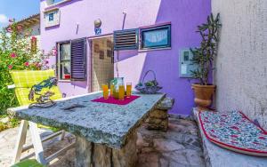 un edificio púrpura con una mesa con bebidas. en Ferienhaus für 5 Personen ca 70 qm in Rakalj, Istrien Bucht von Raša, en Rakalj
