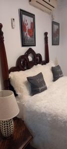 Mandeville Chateau في ماندفيل: سرير عليه أغطية ووسائد بيضاء