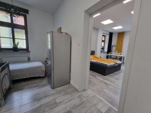 Zimmer mit einem Kühlschrank und einem Schlafzimmer mit einem Bett. in der Unterkunft Przy Rynku Black and White in Tarnowitz