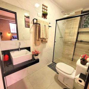 uma casa de banho com um lavatório, um WC e um chuveiro em Apartamento 16 Central em Poços de Caldas em Poços de Caldas