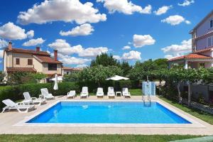 una piscina con tumbonas y sombrilla en Ferienwohnung für 5 Personen ca 48 qm in Medulin, Istrien Südküste von Istrien, en Medulin