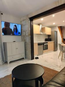 a living room with a table and a tv on the wall at Charmante maison in Niort