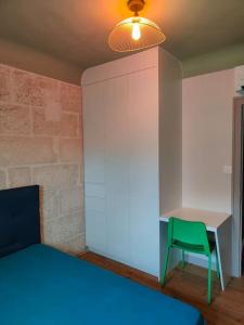 1 dormitorio con silla verde y escritorio en Charmante maison, en Niort