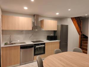 a kitchen with stainless steel appliances and a table at Charmante maison in Niort