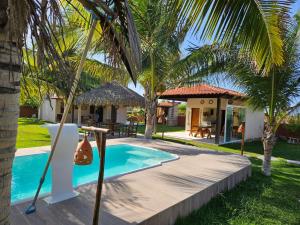 a villa with a swimming pool and a house at Rota do Mar in Luis Correia