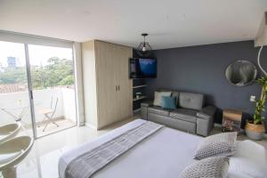 1 dormitorio con cama, sofá y TV en Mio Loft en Medellín