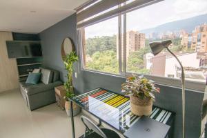 a living room with a couch and a table in front of a window at Mio Loft in Medellín