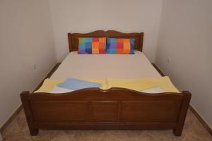 a bed with a wooden frame and a pillow on it at Apartments Morinj in Donji Morinj