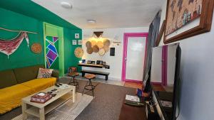a living room with a yellow couch and colorful walls at Mango Haus in Aqaba
