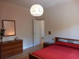 a bedroom with a red bed and a mirror at Casa Foresto, Vallombrosa, wifi, pet friendly in Tosi