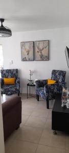 a living room with two chairs and a couch at Residencial Palmas De Gurabo in Santiago de los Caballeros