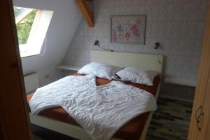 Ferienwohnung am Stadtrand von Demmin في دمين: غرفة نوم بسريرين وملاءات بيضاء ونافذة