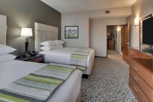 a hotel room with two beds and a flat screen tv at Drury Plaza Hotel Savannah Pooler in Savannah