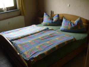 Una cama con tres almohadas encima. en Ferienwohnung mit Terrasse und Parkplatz - a78602 en Igersheim