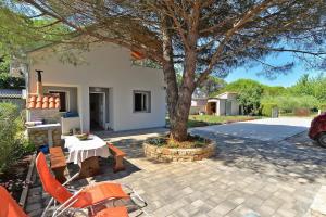 un patio con mesa, sillas y un árbol en Ferienwohnung für 4 Personen ca 42 qm in Fažana-Surida, Istrien Istrische Riviera - b55096, en Valbandon