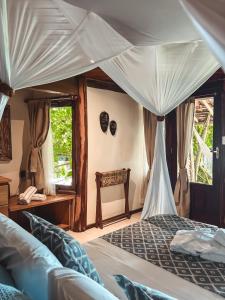 1 dormitorio con cama con dosel y ventanas en Pousada Sage Point, en Itacaré