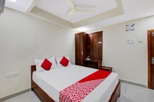 um quarto com uma cama com almofadas vermelhas em Super OYO Flagship Hotel Millennia em Visakhapatnam