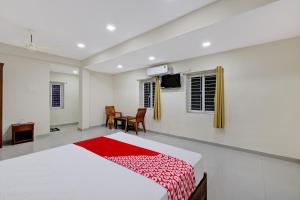um quarto com uma cama, uma mesa e cadeiras em Super OYO Flagship Hotel Millennia em Visakhapatnam