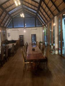 ein großes Esszimmer mit einem Holztisch und Stühlen in der Unterkunft free tribe in Chiang Mai