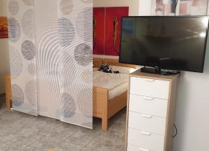 einen Fernseher auf einer Kommode in einem Zimmer in der Unterkunft Strandurlaub im Ferienappartement mit Garten - b57340 in Heiligenhafen