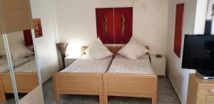 Kleines Zimmer mit einem Bett und einem TV in der Unterkunft Strandurlaub im Ferienappartement mit Garten - b57340 in Heiligenhafen