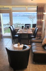 ein Esszimmer mit einem Tisch und Stühlen sowie einem großen Fenster in der Unterkunft Strandurlaub im Ferienappartement mit Garten - b57340 in Heiligenhafen