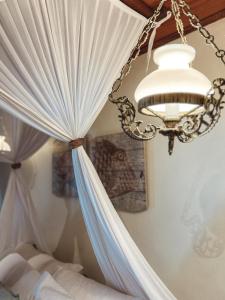 um quarto com uma cama com uma cortina e um lustre em Pousada Sage Point em Itacaré