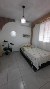- une chambre avec un lit et une plante en pot dans l'établissement Departamento Citrino, à Godoy Cruz