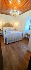 a bedroom with a white bed with a chandelier at Carlana House in Paredes de Coura +10 photos