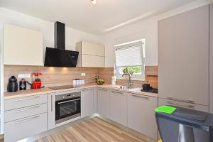 a kitchen with white cabinets and a sink and a window at Ferienhaus für 4 Personen ca 74 qm in Medulin, Istrien Südküste von Istrien in Medulin +14 photos