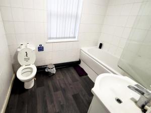 a bathroom with a toilet and a sink and a tub at Stay Sleep Rest - Grove Haven in Hull