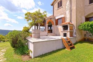 eine Außenansicht eines Hauses mit einer Bank im Hof in der Unterkunft Ferienwohnung für 4 Personen in Rogocana, Istrien in Labin
