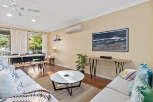 a living room with a couch and a table at Swim Spa- 5mins to beach and golf - Pet Friendly in Shelly Beach