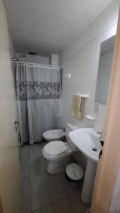 La salle de bains blanche est pourvue de toilettes et d'un lavabo. dans l'établissement Departamento Citrino, à Godoy Cruz