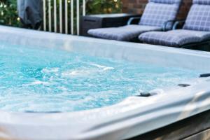 a hot tub with blue water on a patio at Swim Spa- 5mins to beach and golf - Pet Friendly in Shelly Beach