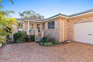 a brick house with a garage at Swim Spa- 5mins to beach and golf - Pet Friendly in Shelly Beach