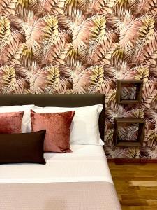 a bedroom with a large bed with a floral wallpaper at Domus Cuseni in Taormina