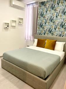 un letto in una camera da letto con carta da parati blu e bianca di Domus Cuseni a Taormina