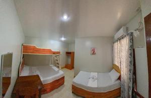 Un dormitorio con dos literas y una mesa. en Strong Tower Inn, en El Nido