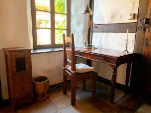 a wooden desk with a chair next to a window at Ferienhaus Waffenkammer mit 3 Schlafräumen in Leppersdorf